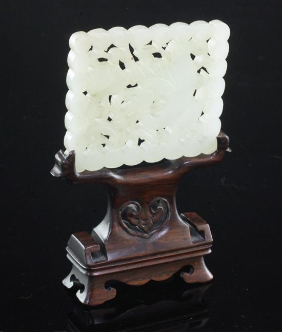 A Chinese pale celadon jade plaque, 18th / 19th century, 6.1cm, wood stand